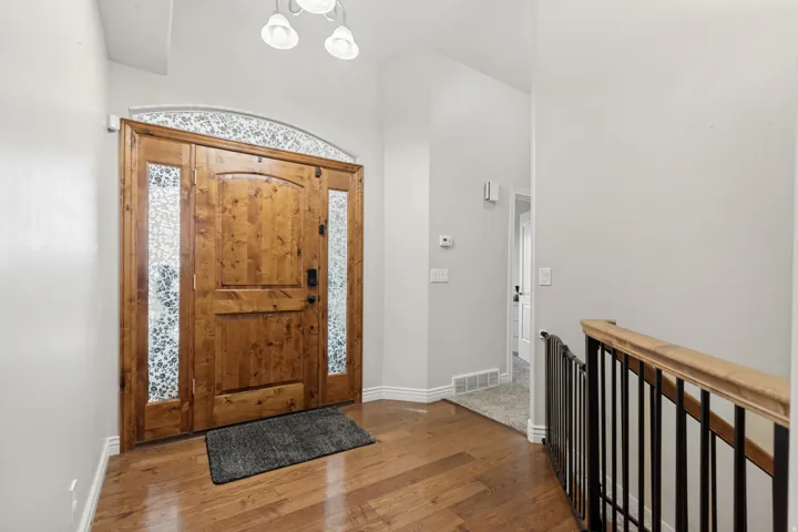 Entryway featuring a solid wood front door with decorative glass sidelights and transom