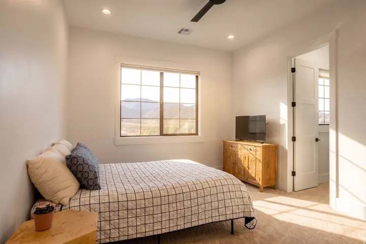 Bedroom featuring a grid-paned window, mountain scenery, recessed lighting, a ceiling fan, and carpet flooring