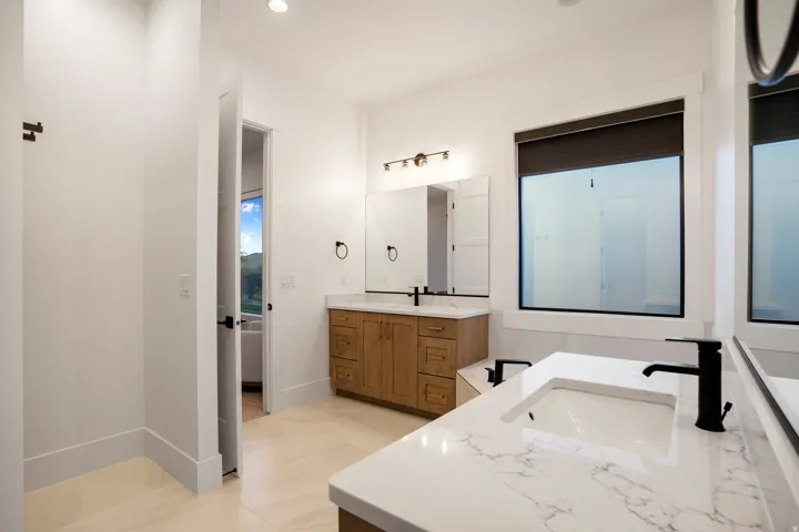 Dual vanity featuring white countertops with integrated sinks and matte black fixtures