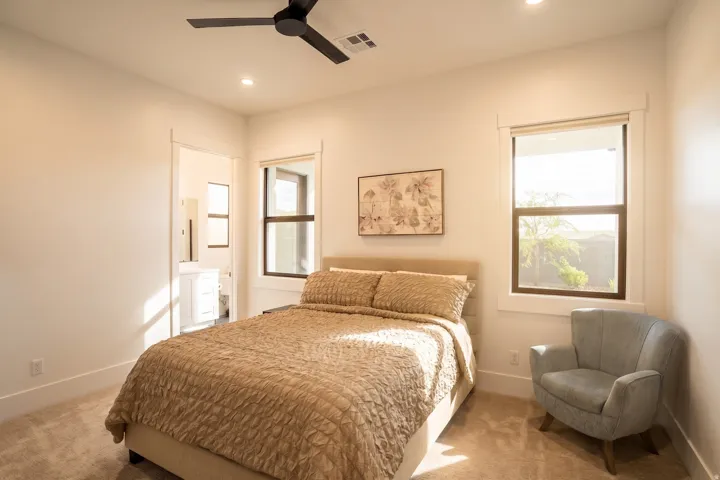 Carpeted bedroom with a black ceiling fan, recessed lighting, and dual windows