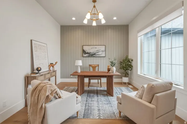 Spacious room featuring wood-finish flooring and a paneled accent wall