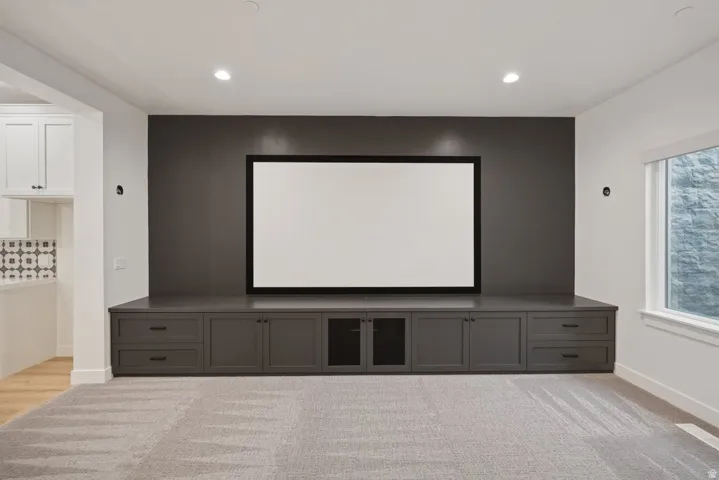 Built-in media center featuring a large screen, dark cabinetry, and integrated storage
