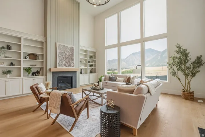 Spacious living area featuring a two-story ceiling and wide plank wood-finish flooring