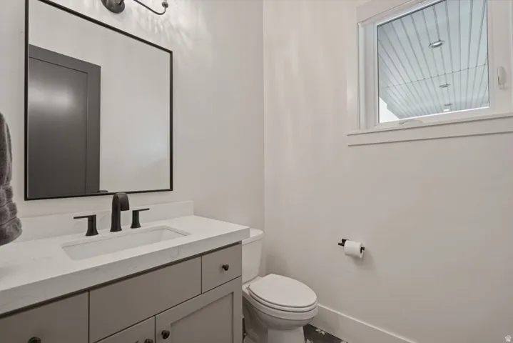 Contemporary bathroom featuring a light gray vanity with a white countertop, an undermount sink, and matte black fixtures