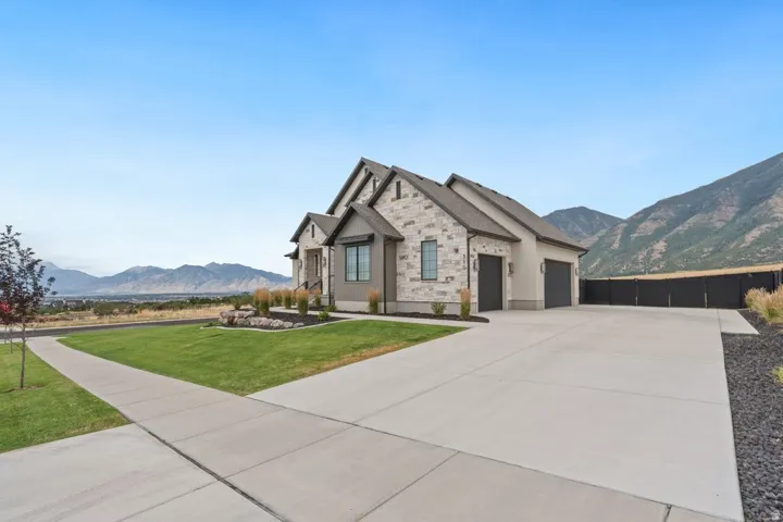 Single-story residence featuring a stone and stucco exterior, a two-car garage, and a concrete driveway
