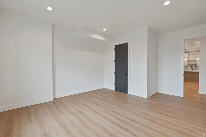 Room featuring light wood-finish flooring, white walls, and recessed lighting