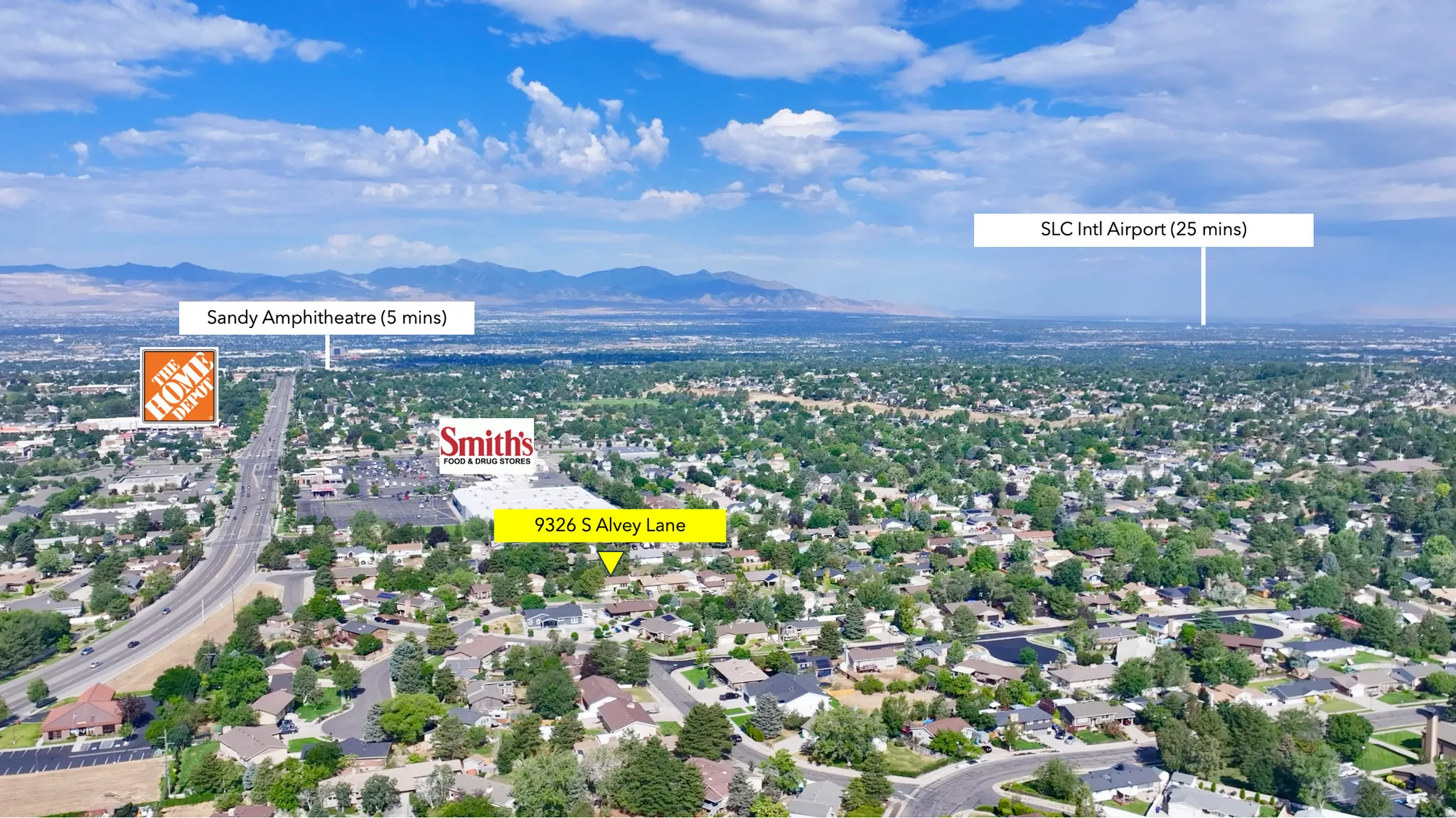 Aerial perspective showcasing a residential area with surrounding commercial establishments and distant mountains
