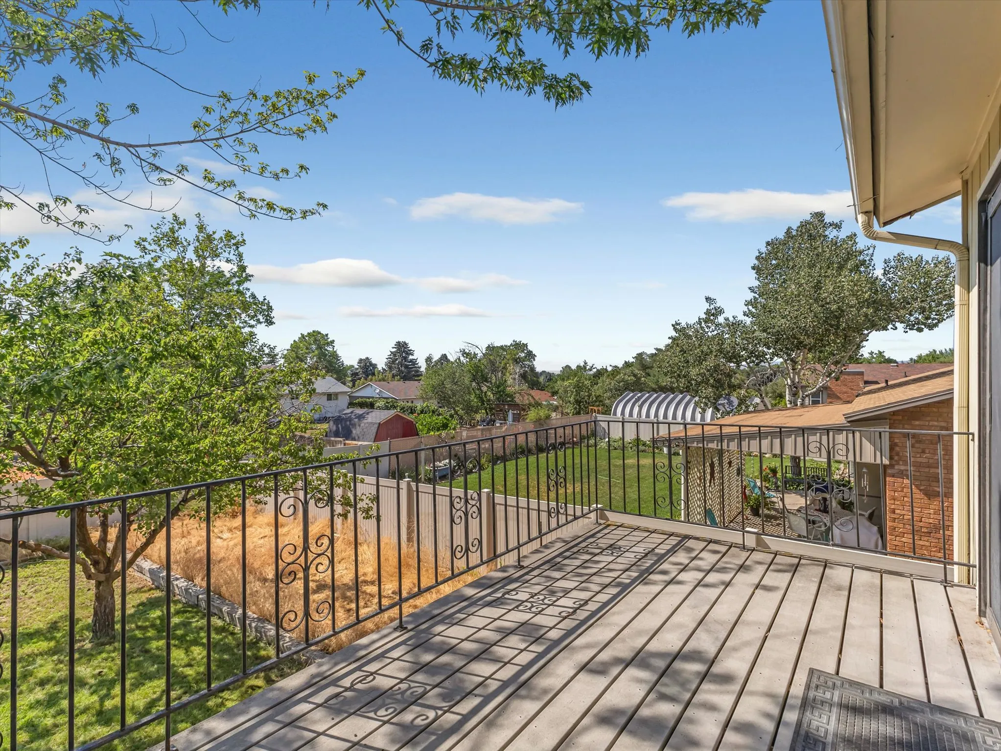 Expansive outdoor deck featuring wood-finish flooring and black metal railing