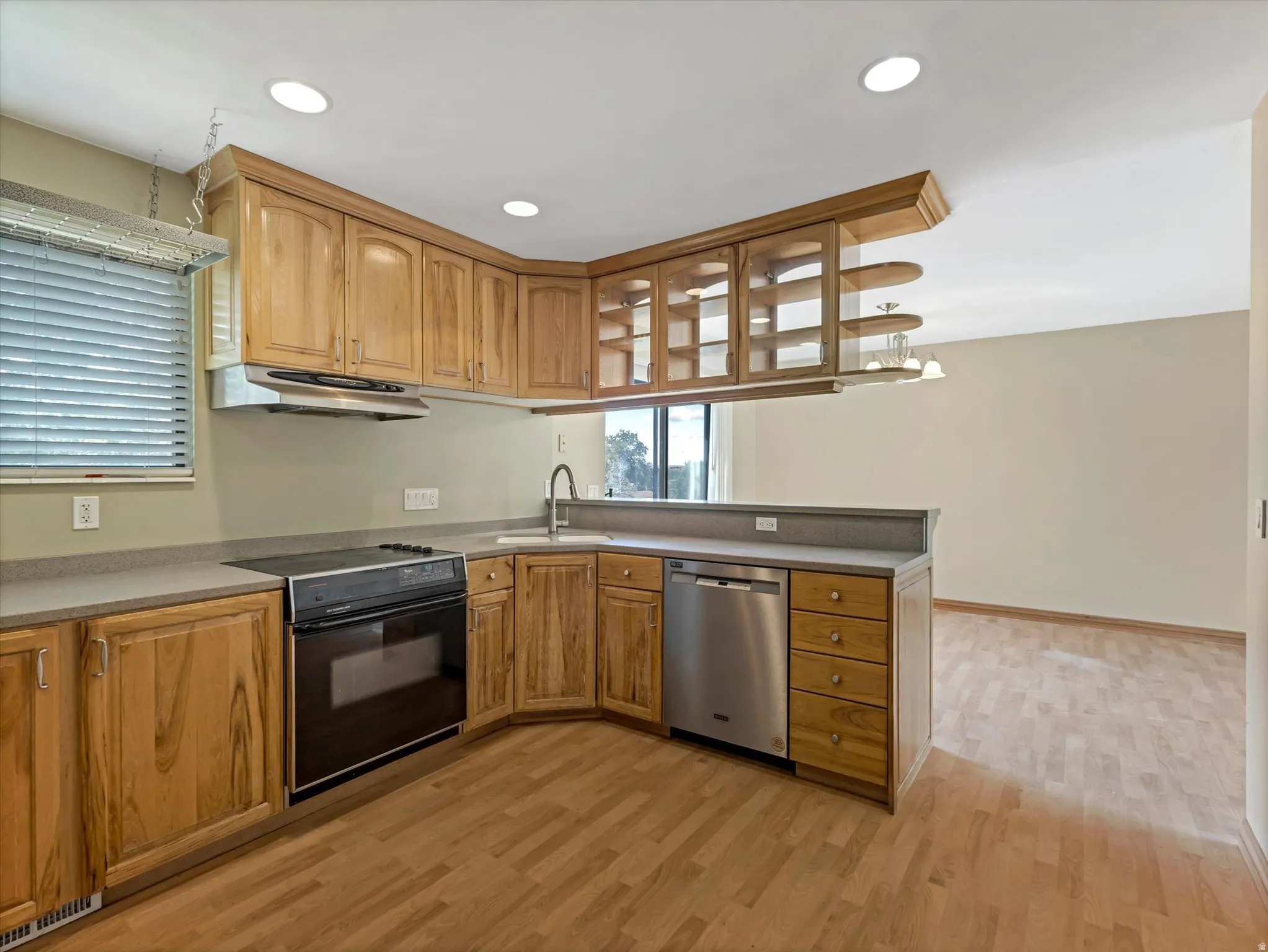 Kitchen featuring wood cabinetry, stone-finish countertops, stainless steel appliances, and recessed lighting