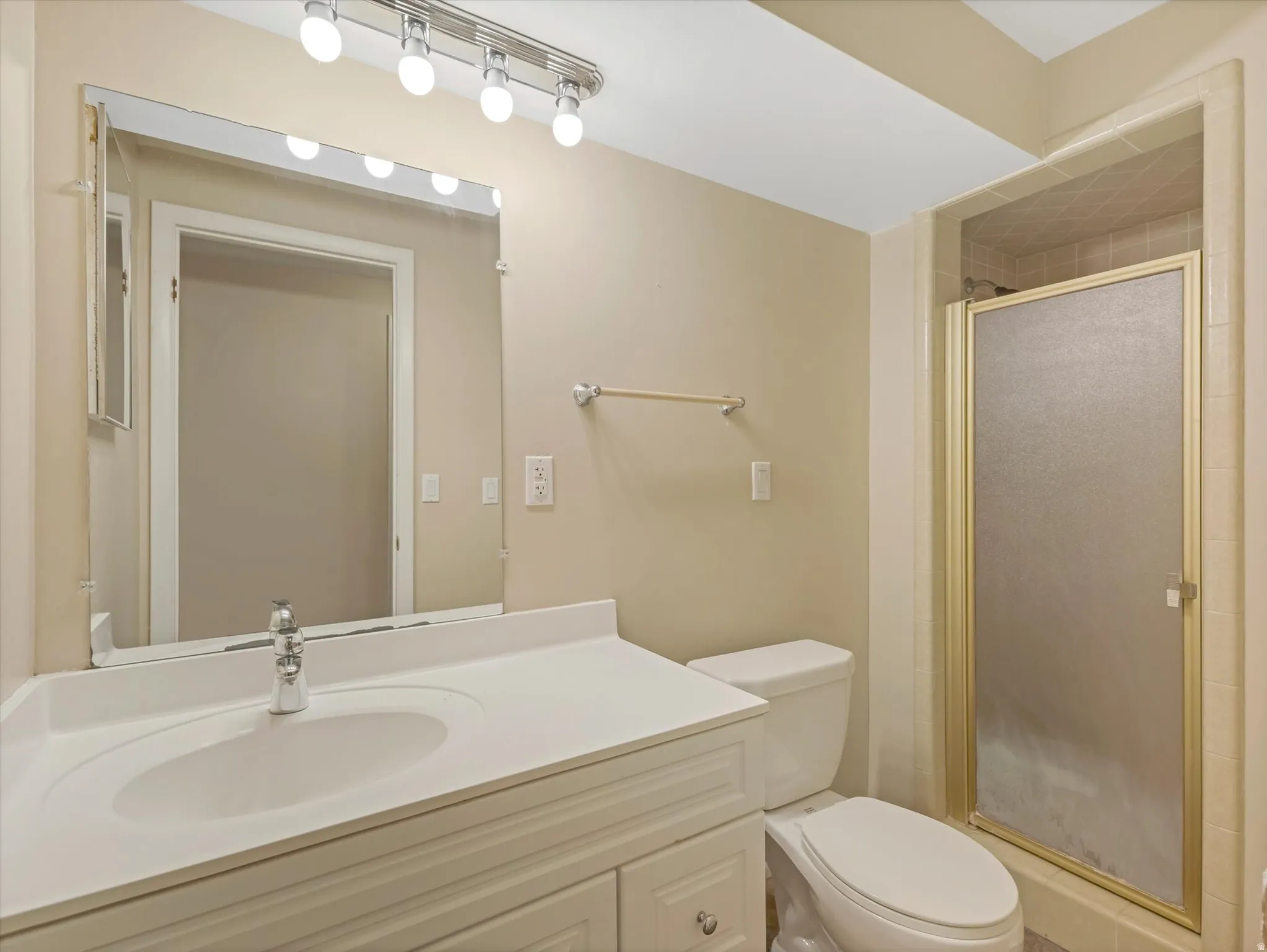 Bathroom featuring a white vanity with integrated sink, chrome faucet, and a large wall-mounted mirror