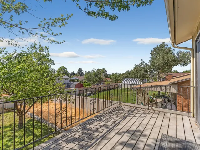 Expansive outdoor deck featuring wood-finish flooring and black metal railing