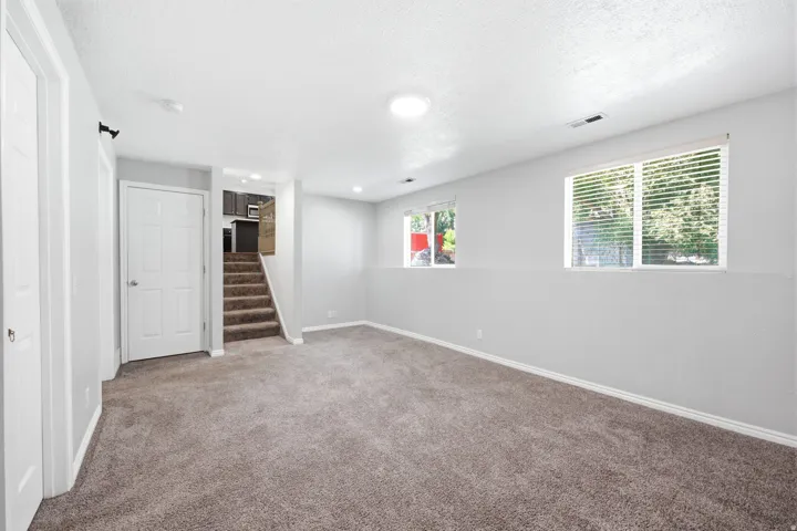 Spacious interior room featuring carpeted flooring and light grey wall finishes