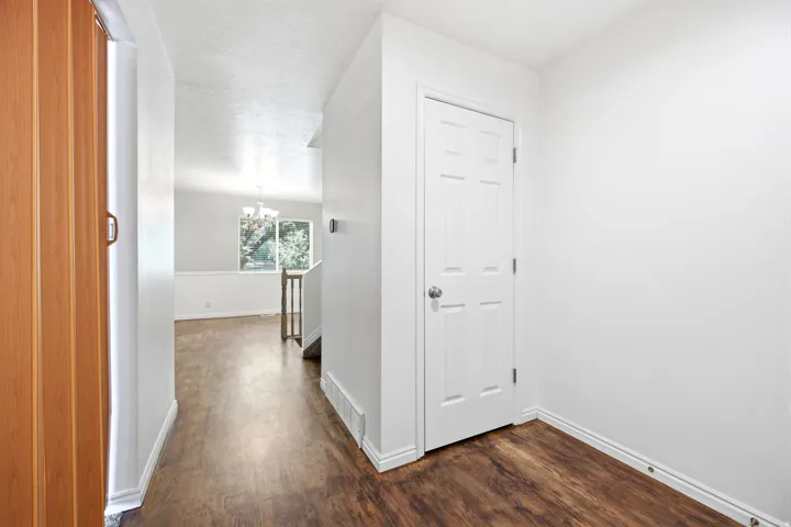 Entryway with wood-finish flooring, white trim, and a paneled white door