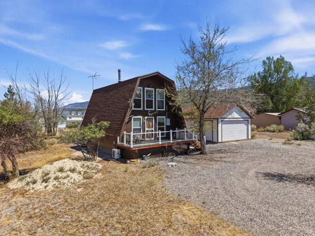A-frame residence featuring a brown shingle roof and white trim