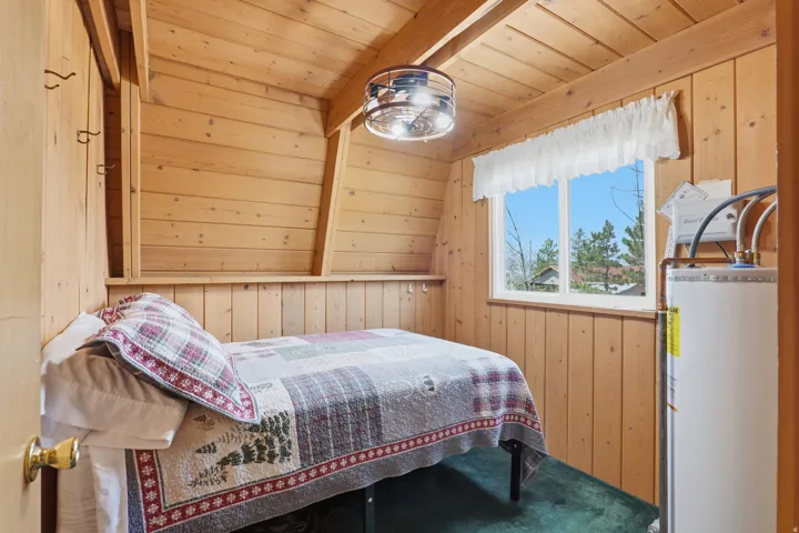 Room featuring wood-paneled walls and ceiling, a window with white trim, and a semi-flush mount ceiling light fixture