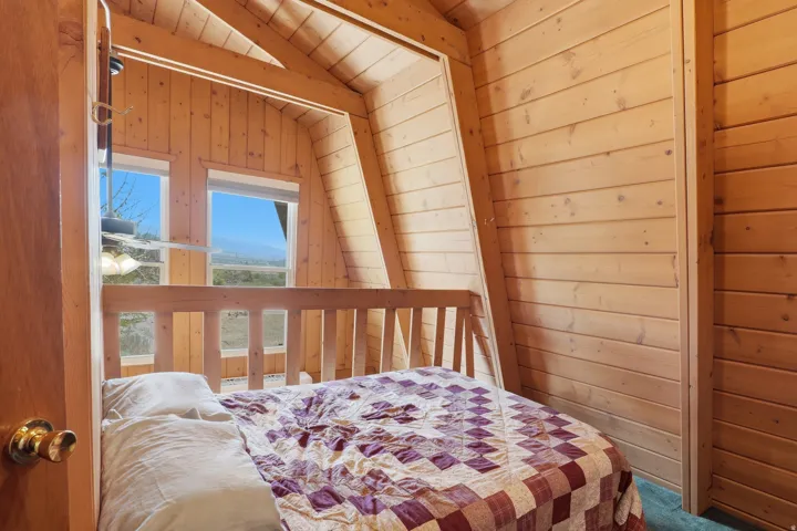 Interior room featuring extensive wood-finish paneling, a vaulted wood-finish ceiling with exposed beams, and a built-in wood-finish railing
