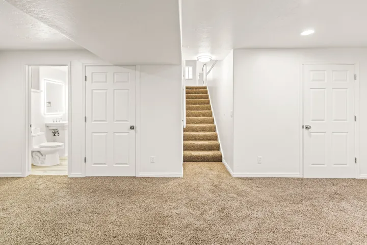 Carpeted space with white walls and trim