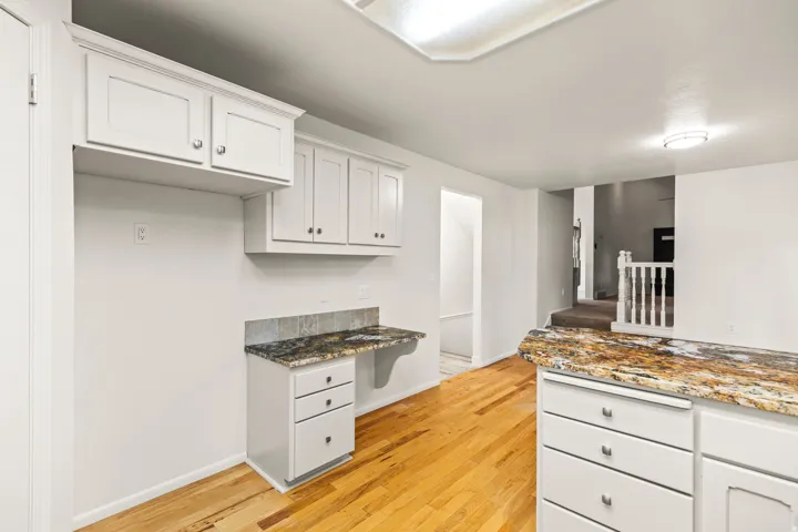 Kitchen area featuring light wood-finish flooring and white cabinetry