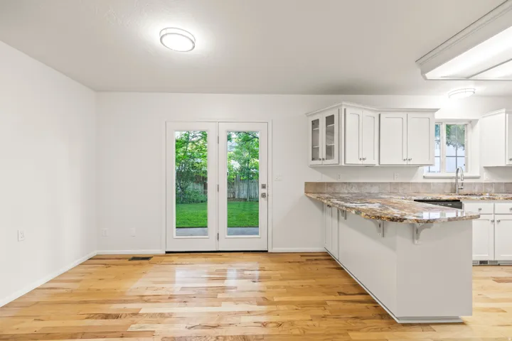 Hardwood-style flooring throughout a bright interior with white walls