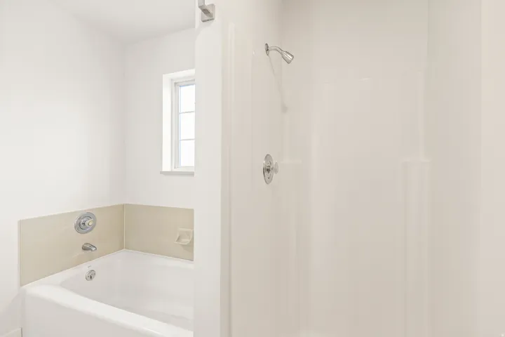 White tub and shower combination with chrome fixtures