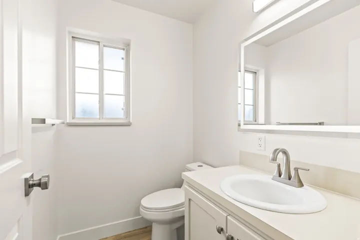 Bathroom featuring a single vanity with a neutral countertop, undermount sink, and brushed nickel faucet