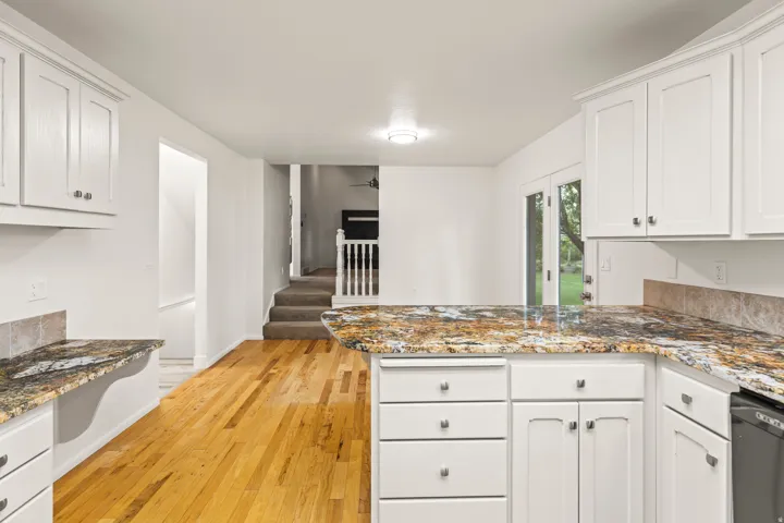 Kitchen featuring white cabinetry and granite countertops