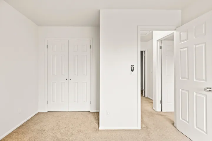 Light-toned carpeting complements the pristine white walls