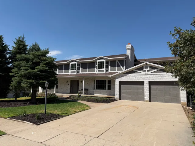 Two-story residence featuring a white brick and gray siding exterior