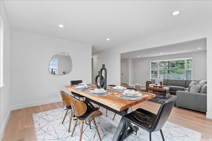 Open-concept dining area featuring light wood-finish flooring and recessed lighting