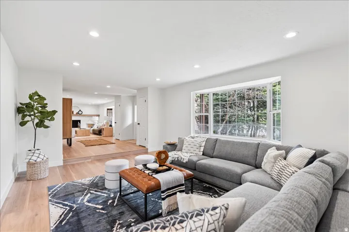 Bright living space featuring a large bay window, recessed lighting, and light wood-finish flooring