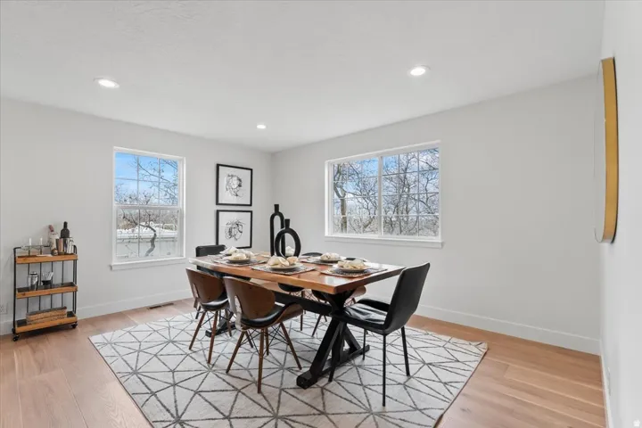 Bright dining area featuring recessed lighting, light wood-finish flooring, and white walls