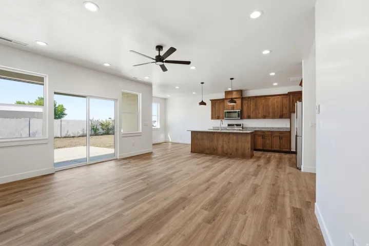 Open-concept living area featuring wood-finish flooring, recessed lighting, and a ceiling fan