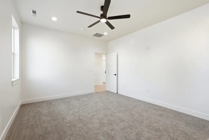 Plush gray carpeting, a modern ceiling fan, recessed lighting, and a white interior door with matte black hardware