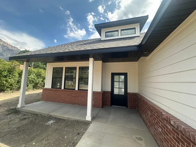 Contemporary exterior featuring white horizontal siding and brick accents