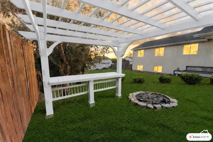 Backyard featuring a wood pergola with a built-in bar, a stone-edged fire pit, and a privacy fence
