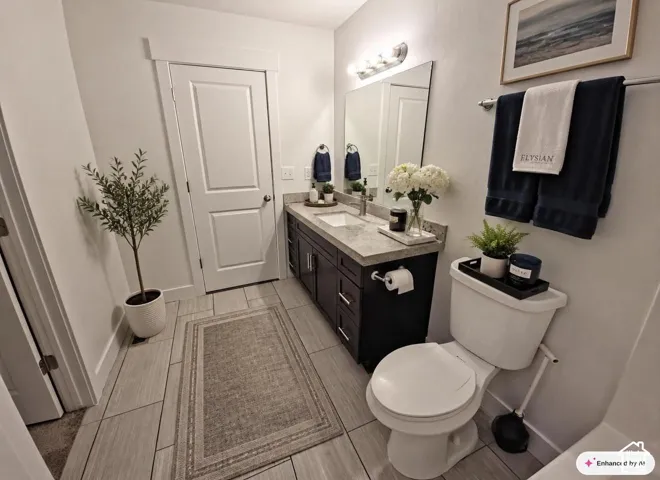 Contemporary bathroom featuring light-toned tile flooring, a dark wood-finish vanity with a light countertop, and a white toilet