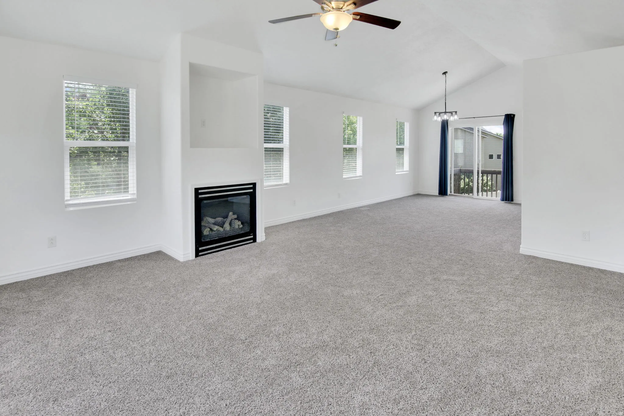 Open concept living area featuring a vaulted ceiling and a ceiling fan