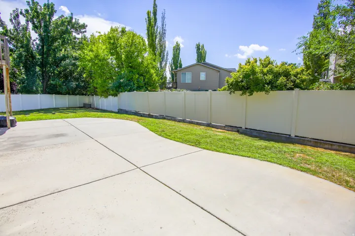 Expansive concrete patio area with a surrounding vinyl privacy fence