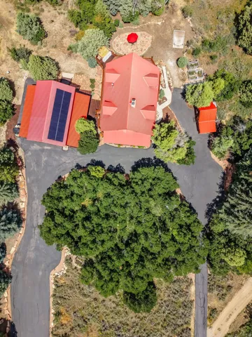 Aerial perspective showcasing a property with a red metal roof and solar panel installation