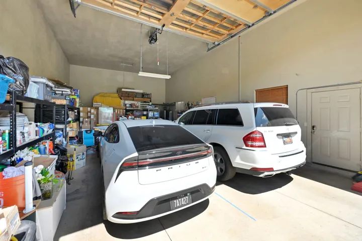 Spacious garage featuring concrete flooring and exposed ceiling joists