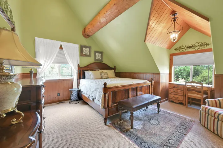 Vaulted ceiling with wood-paneled accents and exposed log beam