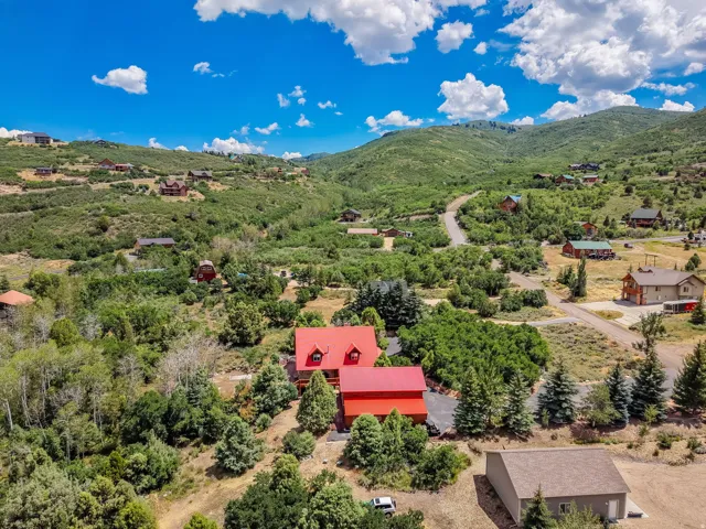 Red-roofed residence set amidst a verdant, mountainous landscape