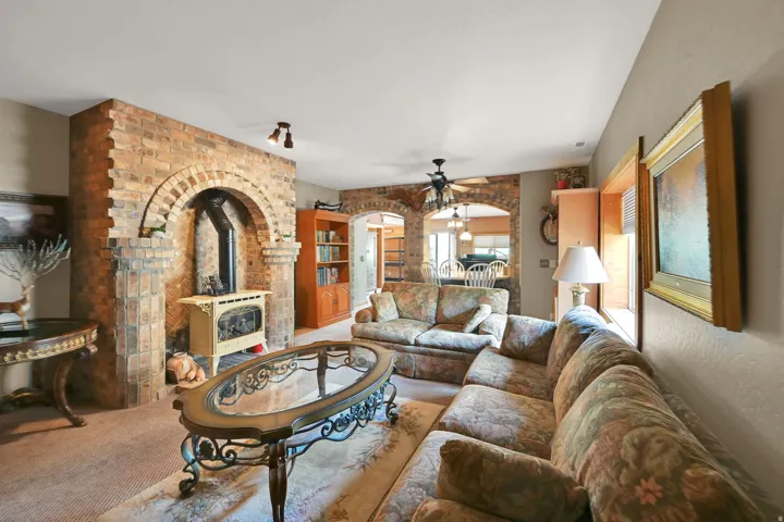Exposed brick fireplace with a wood-burning stove features an arched opening and stone accents