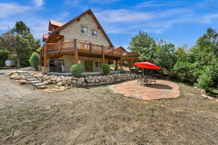Stone-clad exterior featuring a wood balcony with log railings