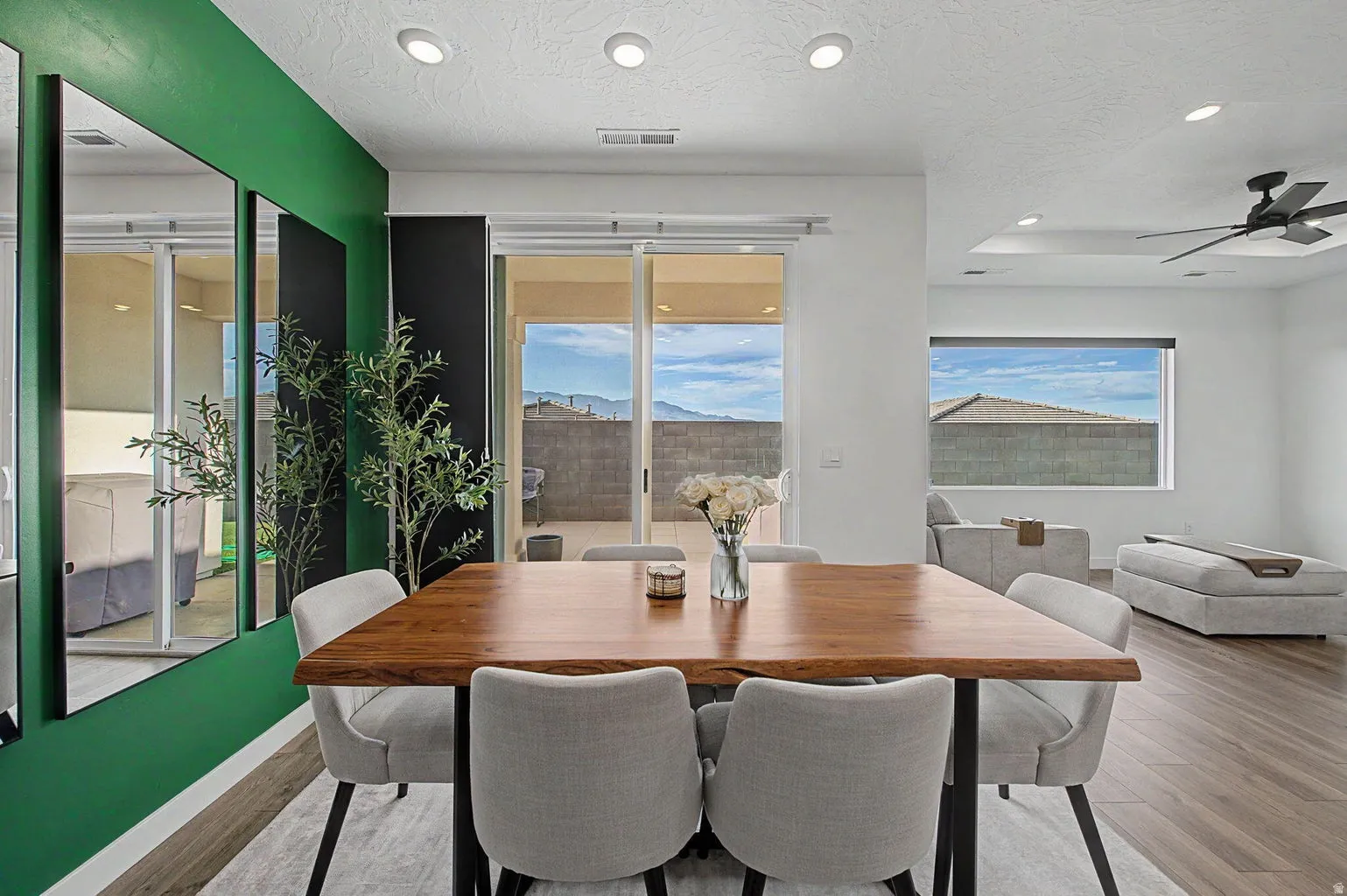 Dining area featuring a solid wood live-edge table, recessed ceiling lighting, and wood-finish flooring