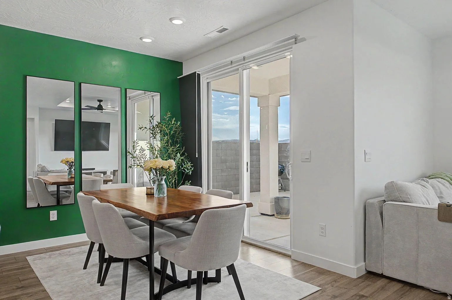 Dining area featuring a vibrant accent wall, recessed lighting, and wood-finish flooring