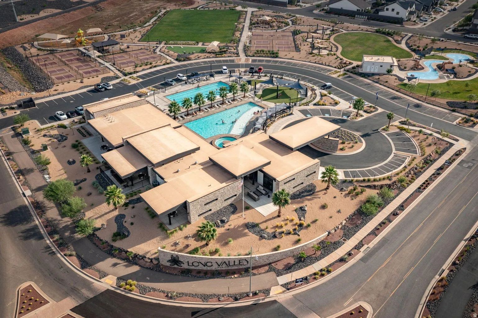Community hub featuring a swimming pool, spa, tennis courts, and a central clubhouse with stone accents