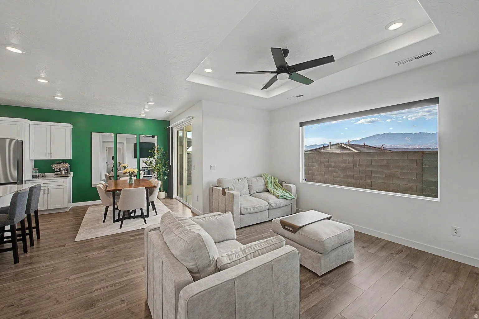 Open-concept living area with wood-finish flooring, a contemporary ceiling fan, and recessed lighting