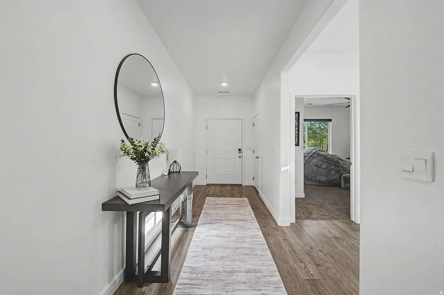 Bright entryway featuring wood-finish flooring, white walls, and recessed lighting