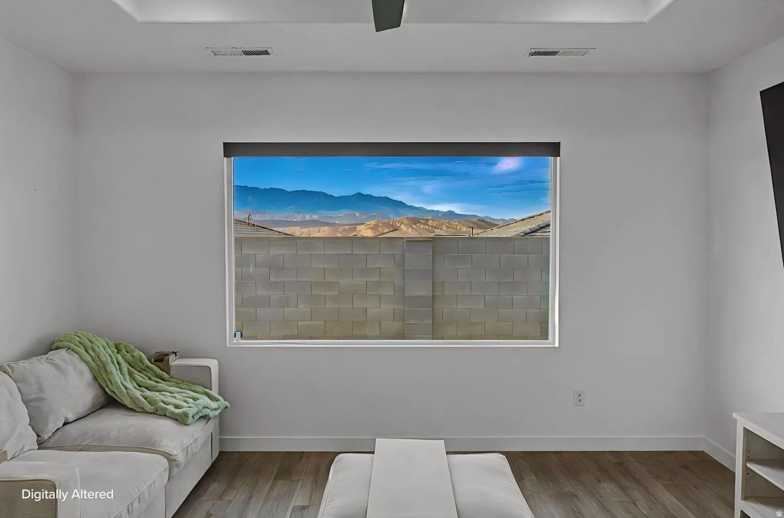 Interior space featuring a large picture window with mountain backdrop, wood-finish flooring, white baseboards, and a recessed ceiling panel